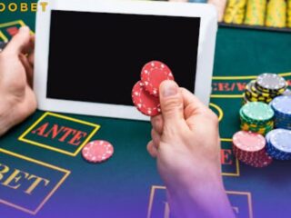 An image of a person on a gaming table with playing chips and a tablet
