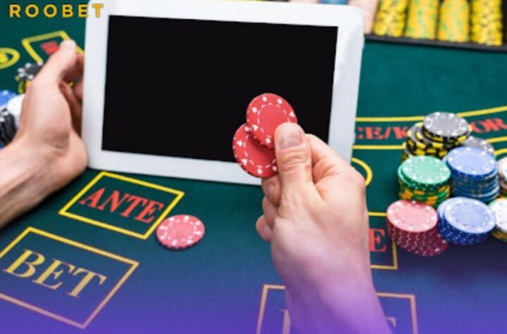 An image of a person on a gaming table with playing chips and a tablet